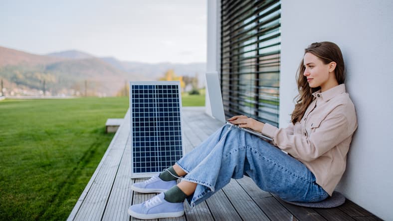 Cómo instalar paneles solares en casa, una chica está solicitando presupuesto con su ordenador a placa a placa